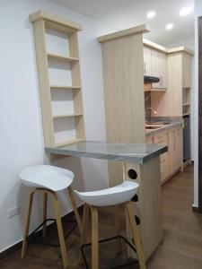 a kitchen with a counter and two stools at Hotel + Arte in Quito
