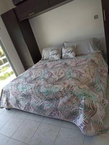 Una cama con un edredón colorido en un dormitorio en Casa Kante, en Puerto Morelos