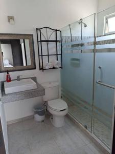 y baño con ducha, aseo y lavamanos. en Casa Kante, en Puerto Morelos