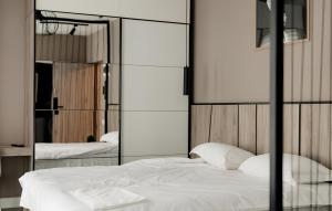 - une chambre avec un lit blanc et un miroir dans l'établissement GAVAS Cozy Studios Central David Prodan, à Cluj-Napoca
