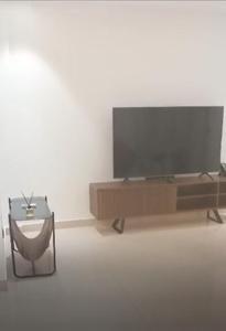 a living room with a flat screen tv and a table at Appartements meublés de haut standing in Yaoundé