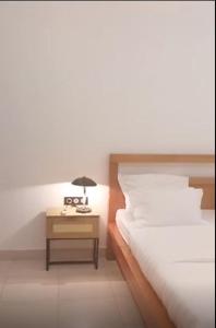 a bedroom with a bed and a nightstand with a lamp at Appartements meublés de haut standing in Yaoundé