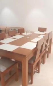 a wooden table with chairs and a vase on it at Appartements meublés de haut standing in Yaoundé