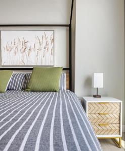 a bedroom with a bed with green pillows at Stunning Rocky Mountain & DT Skyline Views! Near Stampede, Saddledome, BMO Centre! FREE Banff Pass, Wine, & Parking! in Calgary