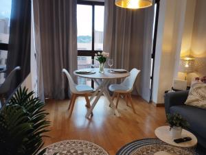 a living room with a table and chairs and a couch at My Suites Madrid - Aeropuerto Ifema in Madrid
