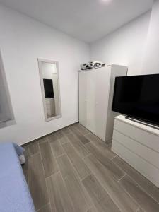 een witte woonkamer met een flatscreen-tv en een flatscreen-tv bij Apartamentos BEACHYDAYS Metrópolis A in Torremolinos +5 foto's