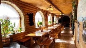 una fila de mesas de madera en una habitación con ventanas en Kwatery u Papieżów en Biały Dunajec