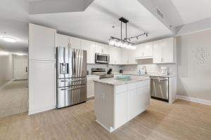 una cucina con armadi bianchi e frigorifero in acciaio inossidabile di Lakeview Luxury at Laketown Wharf #235 by Nautical Properties a Panama City Beach