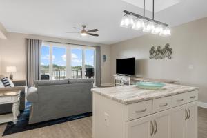 una cucina e un soggiorno con un divano e un tavolo di Lakeview Luxury at Laketown Wharf #235 by Nautical Properties a Panama City Beach Altre 32 foto