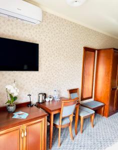 a hotel room with a table and chairs and a television at Hotel&Spa Stary Dziwnów basen swimming pool in Dziwnów