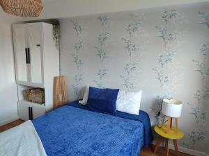 a bedroom with a blue bed and blue wallpaper at zélu apartamento centro da Guarda in Guarda