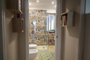 W łazience znajduje się toaleta i przeszklony prysznic. w obiekcie Accademia Apartment w mieście Sassari