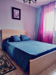 Schlafzimmer mit einem Bett mit blauer Decke in der Unterkunft Casa familiar con finca privada (Orolterra) in Viveiro