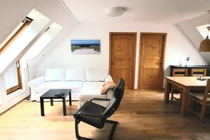 a living room with a white couch and a table at Wohnung am Meer mit Garten in Stralsund