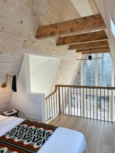 a bedroom with a bed in a room with a balcony at Fox Ridge-Black Alder Lodging in Logan