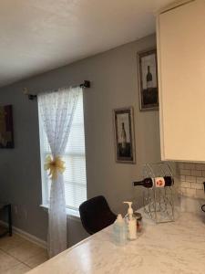 a kitchen with a window with a white curtain at Lovely indoor FPL w/ BBQ / FIREPIT near FSU & FAMU in Tallahassee