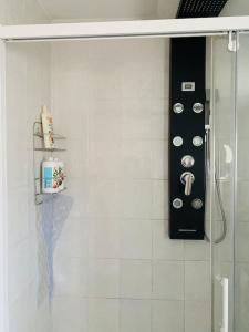 een badkamer met een glazen douchecabine met een zwart voorwerp bij Le Cocon - Petit déjeuner, Netflix, Jacuzzi* in Carrières-sous-Poissy