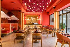 汕埠的住宿－聖佩德羅蘇拉皇家洲際酒店，餐厅拥有红色的墙壁和桌椅