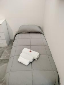 een bed met twee witte handdoeken erop bij Holiday Home Litteri in Catania