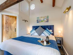 - une chambre avec un lit bleu et blanc et un plateau dans l'établissement 1 Bed in Exmoor 81477, à Challacombe