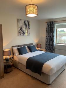 una camera con un grande letto e una finestra di Lakeside House a Ballynahinch