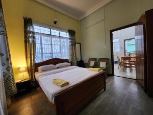 a bedroom with a large bed and a dining room at Cafe Sola bnb in Shillong