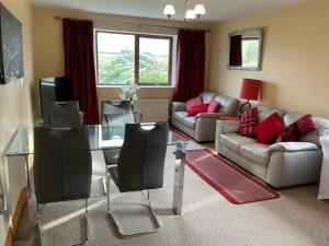 a living room with a couch and a glass table at Lakeside House in Ballynahinch