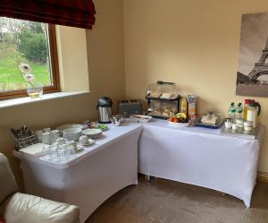 un tavolo bianco con cibo sopra in una stanza di Lakeside House a Ballynahinch