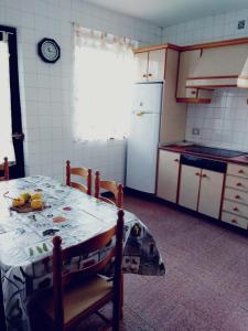 kuchnia ze stołem i owocami w obiekcie Casa familiar con finca privada (Orolterra) w mieście Viveiro