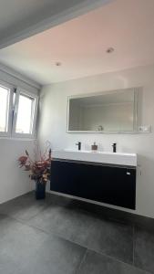 a bathroom with a large sink and a mirror at Casa Pieiteiro in Corcubión