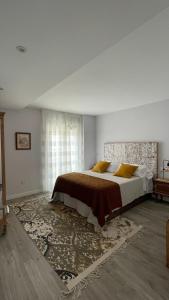 sypialnia z dużym łóżkiem i oknem w obiekcie Casa Pieiteiro w mieście Corcubión