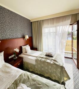 a hotel room with two beds and a window at Hotel&Spa Stary Dziwnów basen swimming pool in Dziwnów