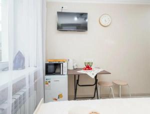 a small kitchen with a small table and a microwave at Отличная студия в центре in Almaty