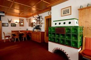 a kitchen and dining room with a green stove at Berggasthof Grabs in Schruns-Tschagguns