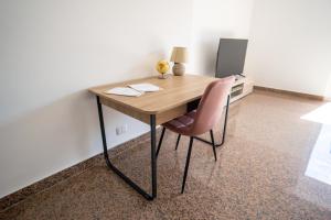 a wooden desk with a pink chair in a room at Casa Erika in Bova Marina
