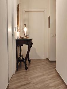a hallway with a table with a lamp on it at La mia casa rosa in Rosignano Marittimo
