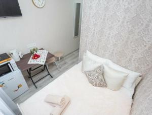 a small room with a bed with pillows and a table at Отличная студия в центре in Almaty
