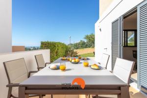 una mesa de comedor en el patio de una casa en #111 Ocean View by Home Holidays, en Vale da Ursa
