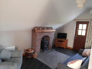 a living room with a brick fireplace and a tv at Quarry Loft in Magherafelt