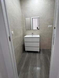 a bathroom with a sink and a mirror at Apartamentos BEACHYDAYS Metropolis B in Torremolinos
