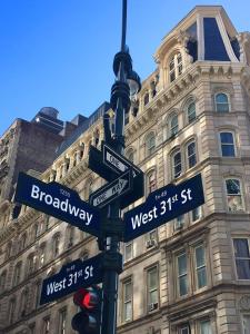 a street pole with street signs and a traffic light at Midtown Nest 1 bedroom Self Serviced Apartment in New York