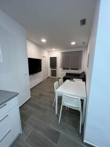 a living room with a white table and chairs at Apartamentos BEACHYDAYS Metropolis B in Torremolinos +7 photos