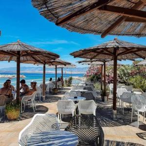 a group of tables and chairs with umbrellas on the beach at DosPalmeras in Vir