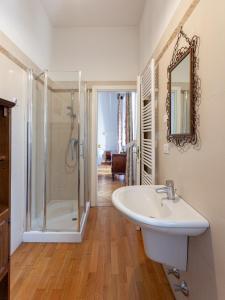 La salle de bains blanche est pourvue d'une douche et d'un lavabo. dans l'établissement Casa Daniela, à Trente