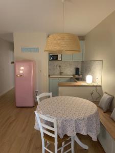 a kitchen with a table and a pink refrigerator at un rêve à la mer in Saintes-Maries-de-la-Mer
