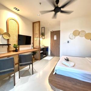 una camera con letto e scrivania con TV di Covesign Suite a Kota Kinabalu