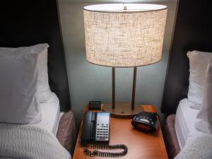 um candeeiro e um telefone numa mesa entre duas camas em Fairfield Inn & Suites Anaheim North Buena Park em Buena Park