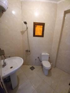 baño con lavabo y aseo y ventana en Locanda Dahab en Dahab