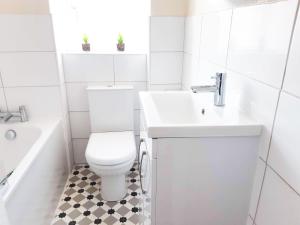 a white bathroom with a toilet and a sink at Pulteney Road Apartment in Bath