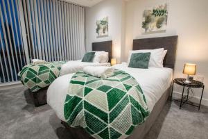 a bedroom with two beds with green and white at Luxury City Centre Apartment (Weekly Booking) in Hull